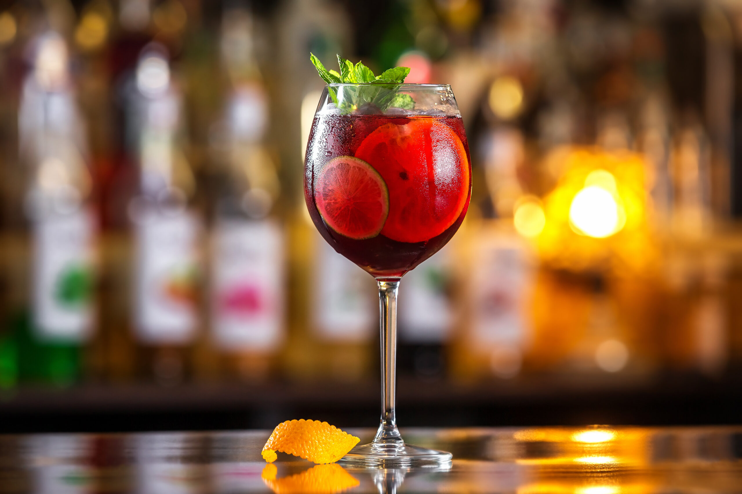Closeup glass of red wine fresh sangria at bright bar counter background.